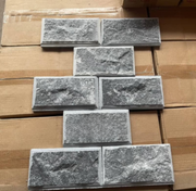 Gạch màu xám xếp hình chữ T trên nền thùng carton nâu.