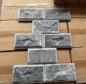 Gạch màu xám xếp hình chữ T trên nền thùng carton nâu.
