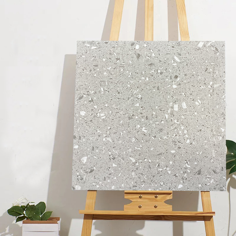 Tấm bảng màu xám có hoa văn đá cẩm thạch, đặt trên giá vẽ gỗ trước tường trắng.