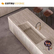 Chất liệu đá travertine màu kem, đảo bếp bằng đá tự nhiên, mặt bàn mài, thiết kế thoát nước vô hình phổ biến